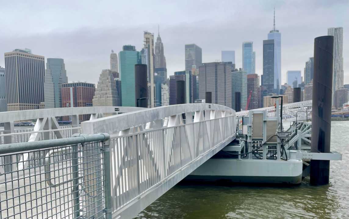 The bridge to the ferry dock at the DUMBO landing with the Manhattan skyline in the background