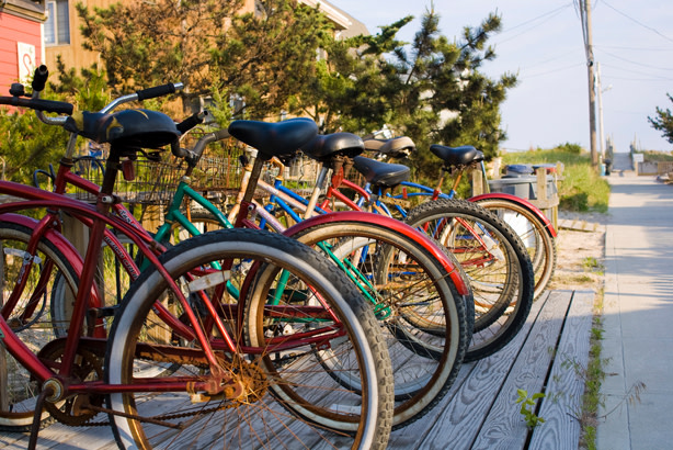 Line of bikes parked along the side of a Fire Island sidewalk-road