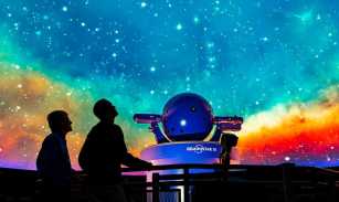 The silhouettes of two people looking up at the ceiling display at the Vanderbilt Space Observatory