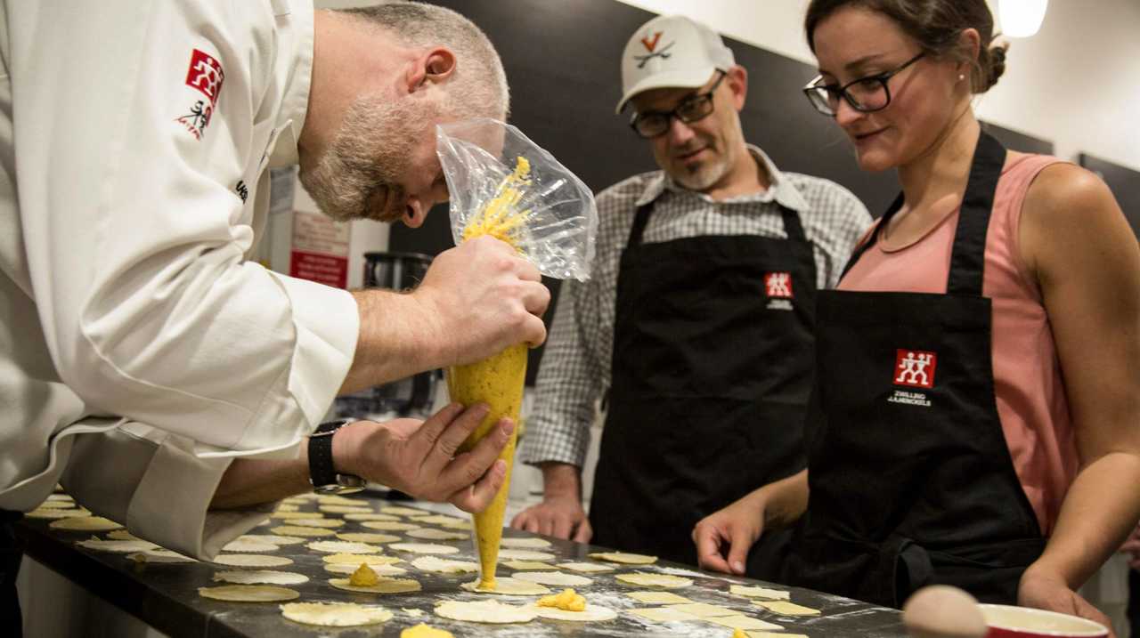 Zwilling Cooking Studio's chef demonstrating ravioli filling in front of two students