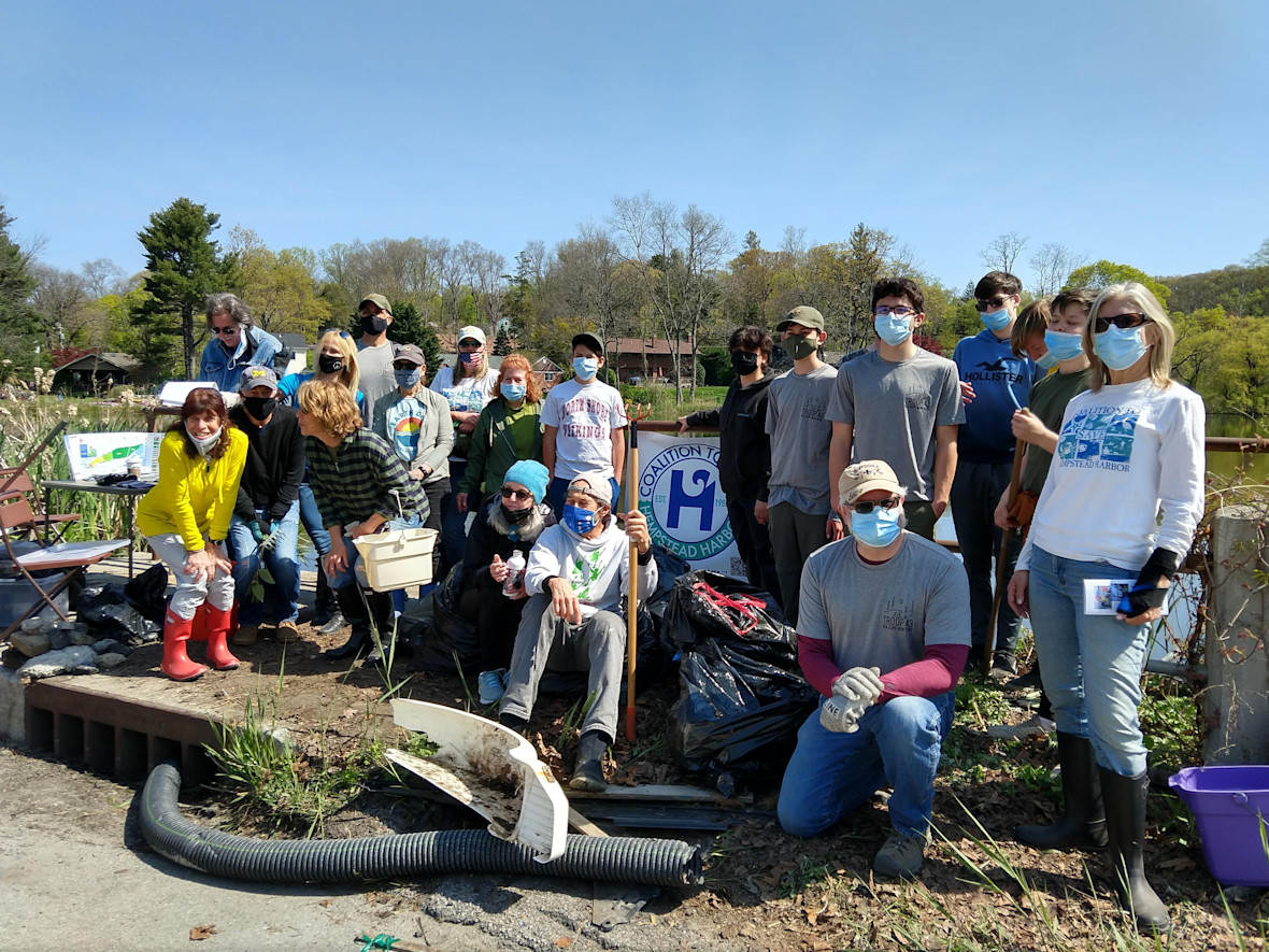 A group of volunteers with The Coalition to Save Hempstead Harbor posing in front of Scudder's Pond