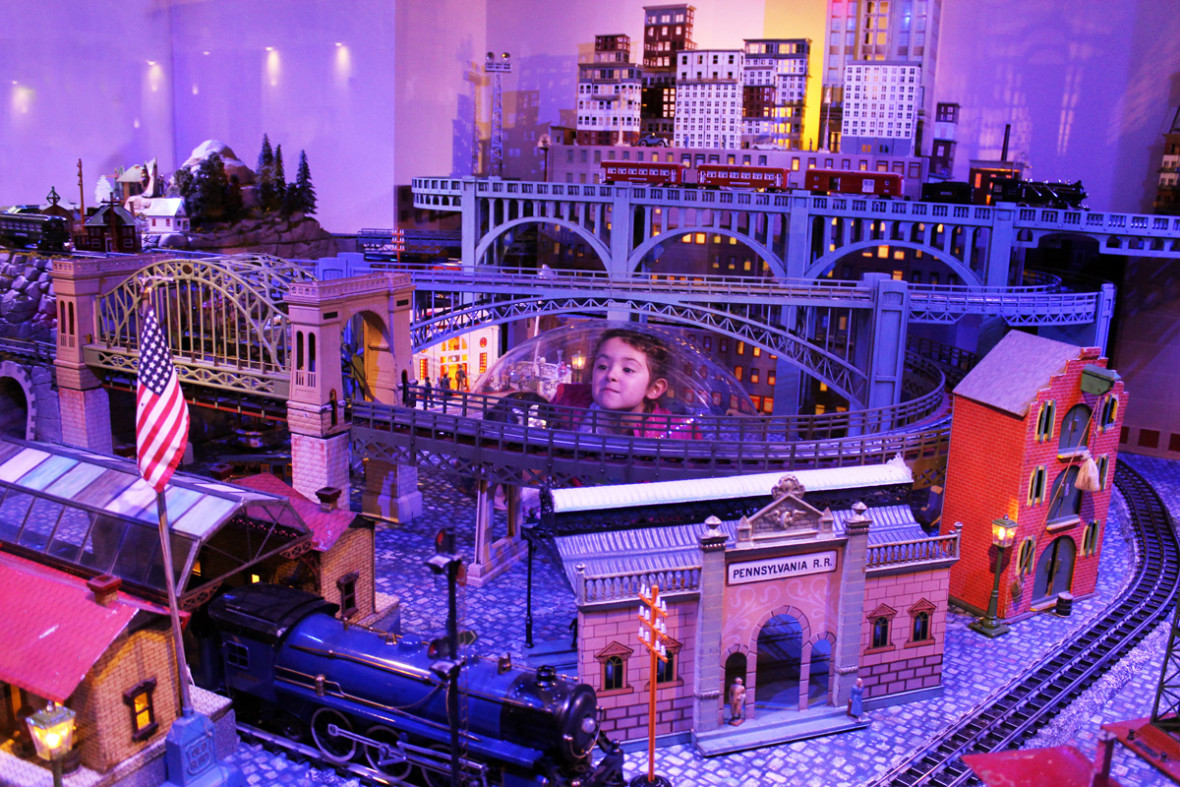 A child enjoys an up-close-and-personal view of the holiday train display at N-Y Historical Society