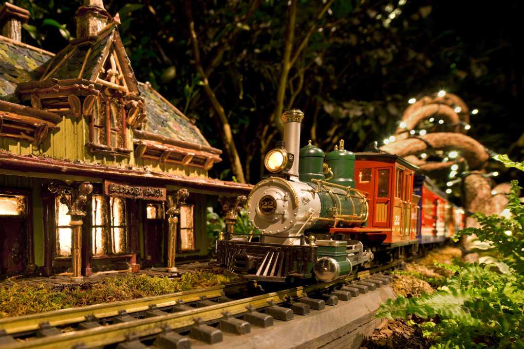 A model train rounds the bend near a miniature Bedford Hills train station at NYBG's holiday train show