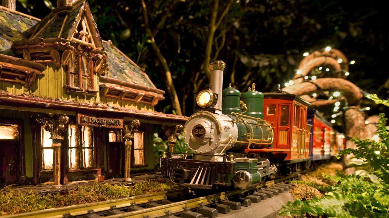 A model train rounds the bend near a miniature Bedford Hills train station at NYBG's holiday train show