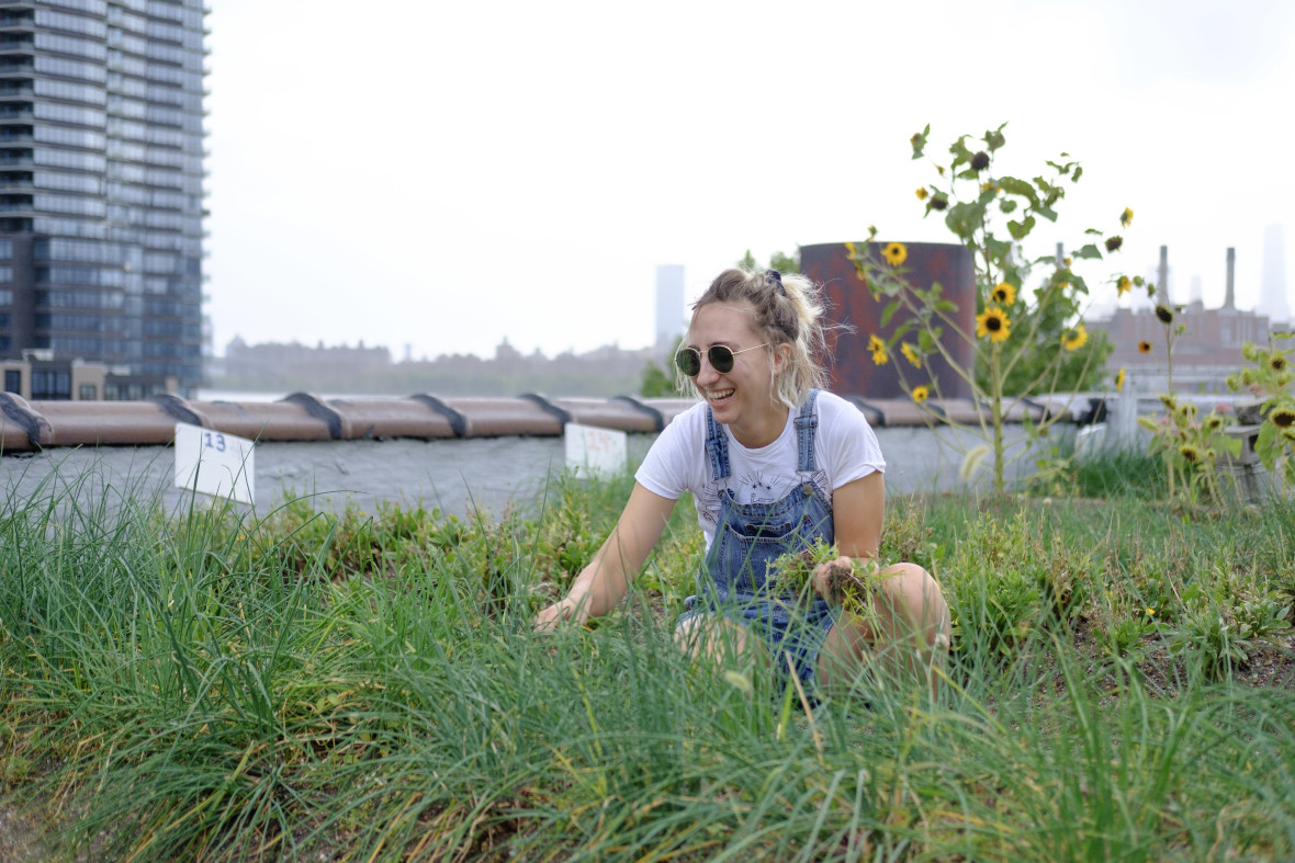 Woman laughing while tending to a rooftop garden at Eagle Street Rooftop Farm