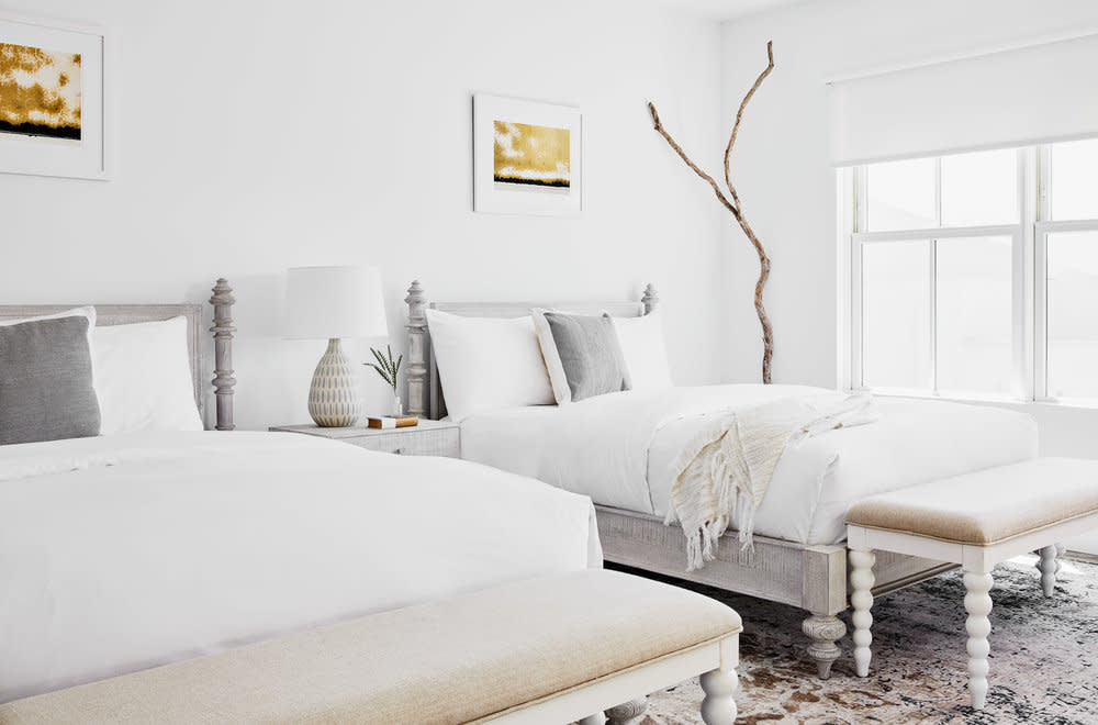An guest room at The Menhaden, decorated in modern white with tan accent pieces