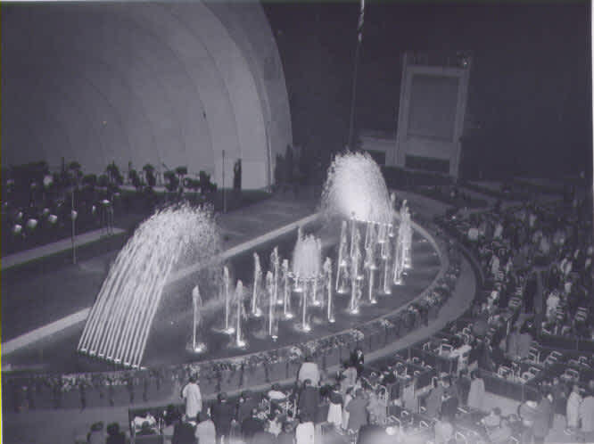 An overhead view of reflecting pool, fountains, and patrons congregating circa 1959. 
