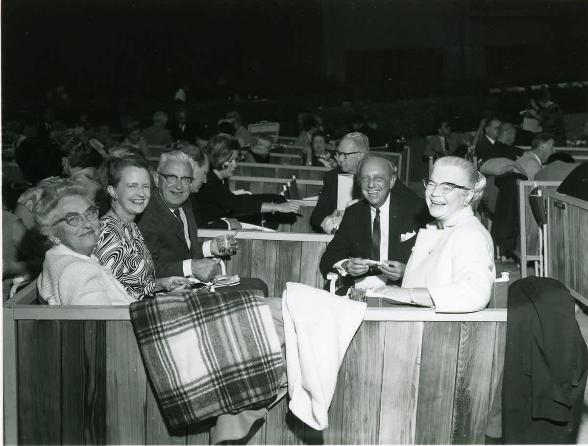 A group of friends enjoys a picnic in the box seats, 1967.