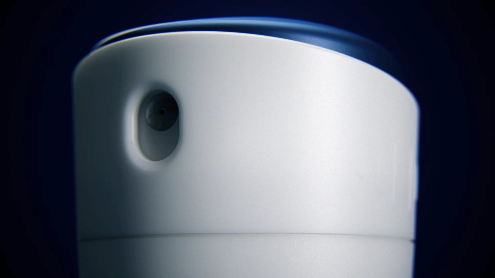 close up of the head of an aerosol packshot with a blue pusher and a white surface