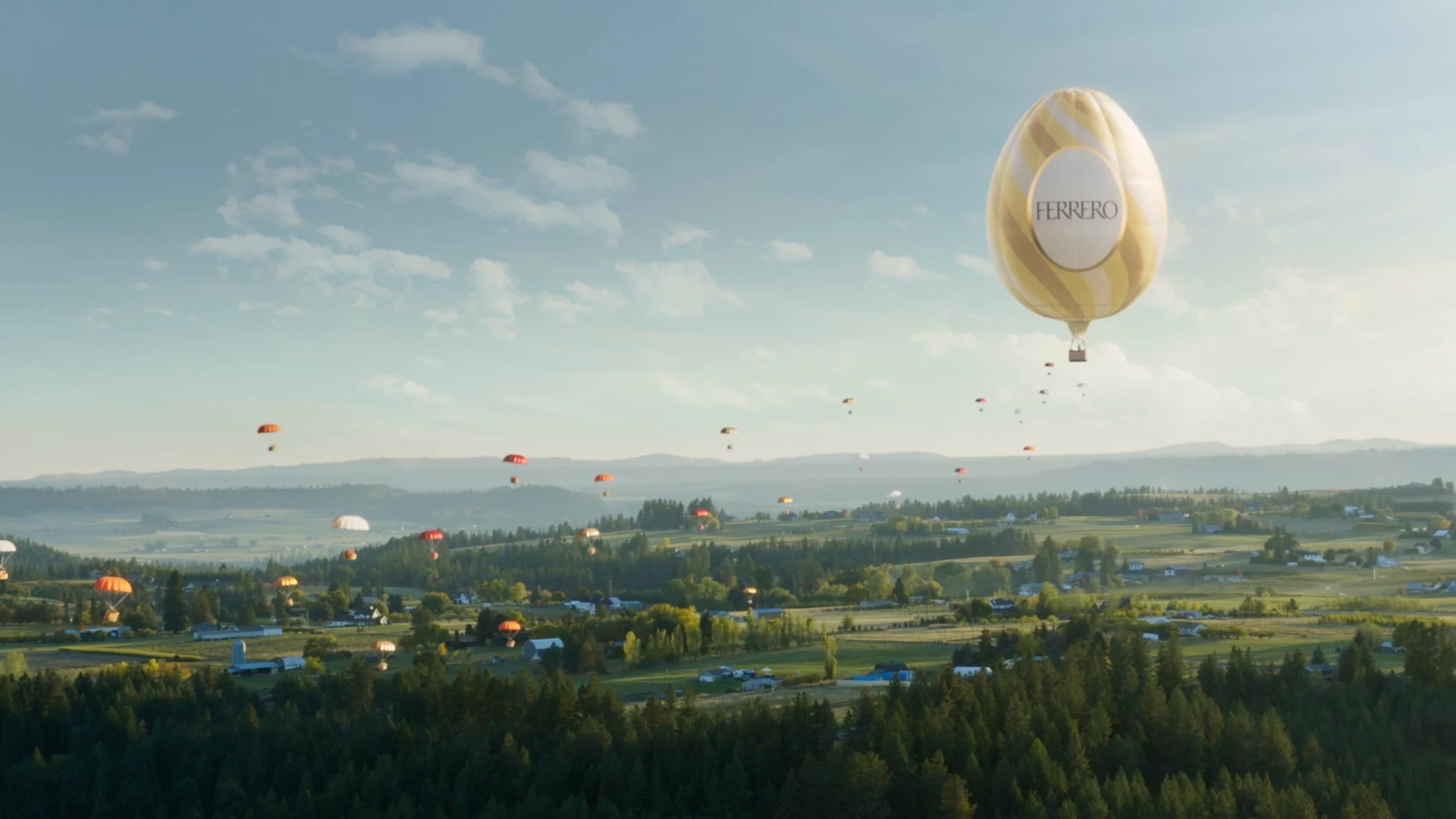 a super wide shot over a green landscape with hills and a blue sky in background in which parachutes and a ballon in the shape of a big easter egg a flying around