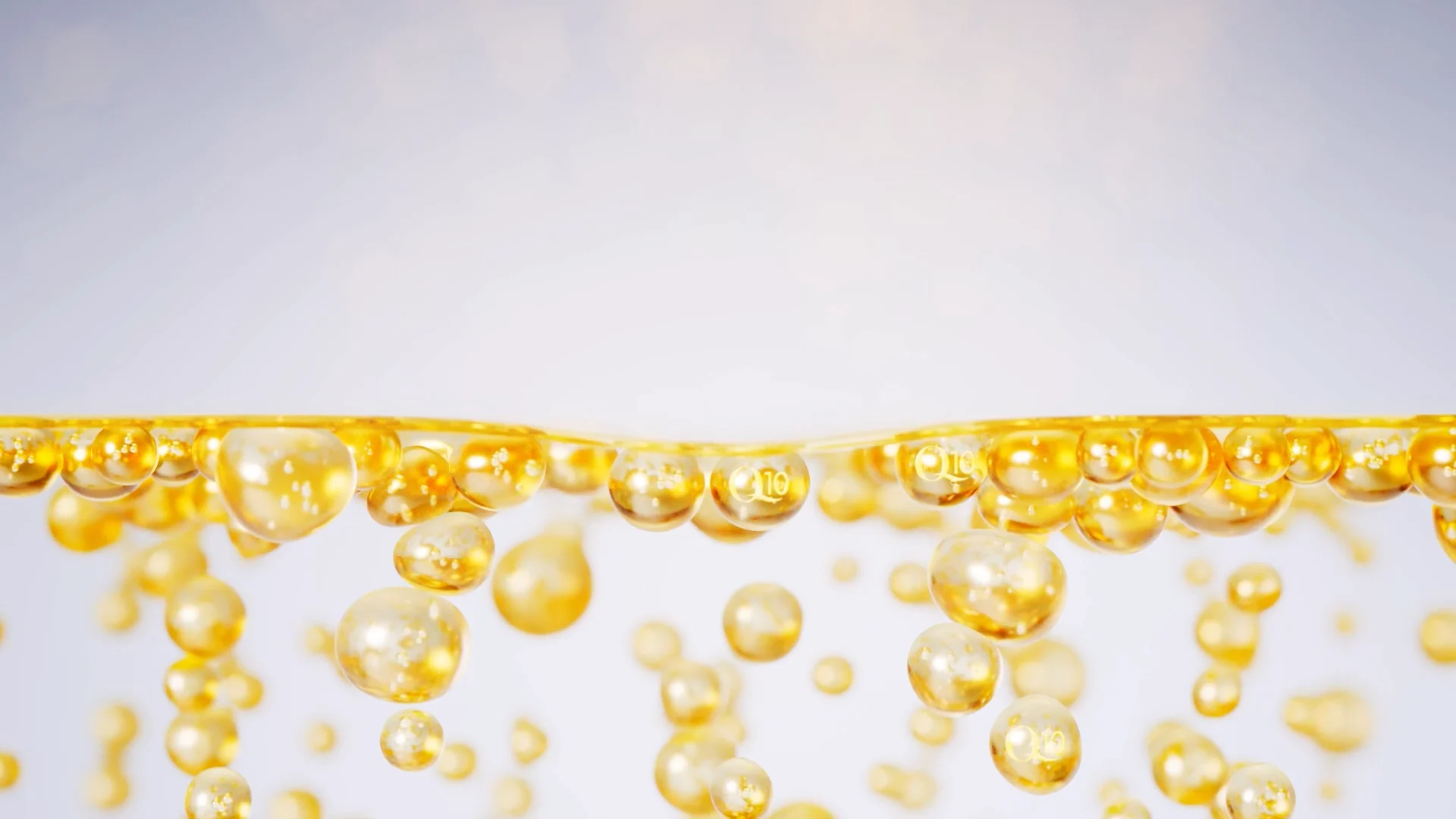 several golden bubbles with littel Q10 letters on it swimming in a transparent liquid