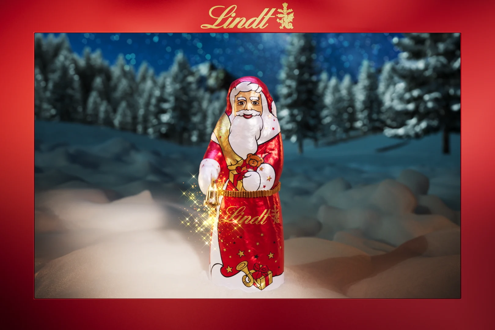we see a chocolate Santa Claus in a snowy environment and a red frame and the picture