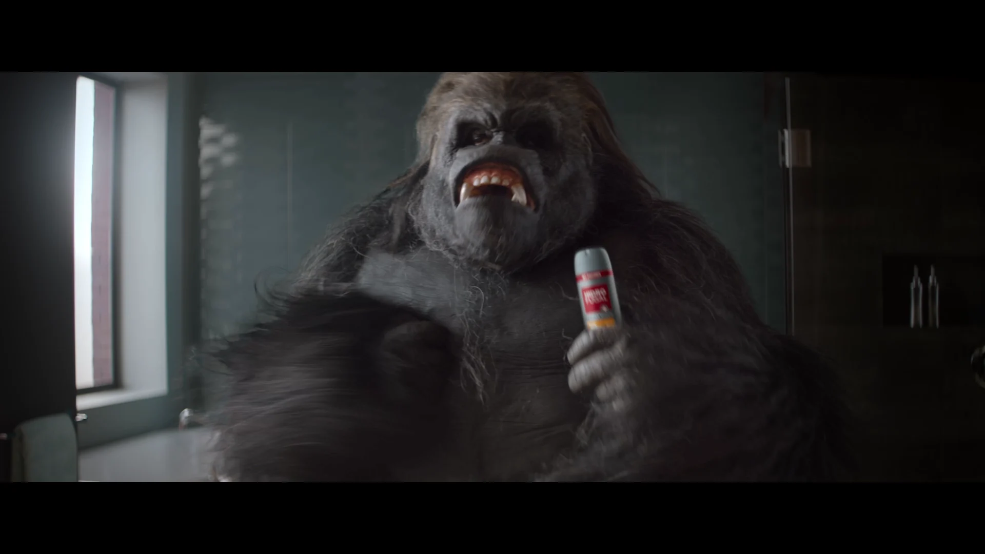 a gorilla in a bathroom holding a hidrofugal men packshot in his hand