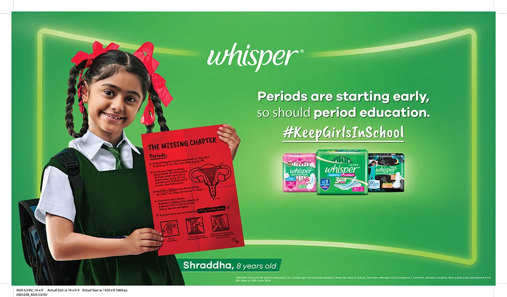 Young indian girl Shraddha, 8 years old, holding a paper containing information about periods. Text beside her: Periods are starting early, so should period education. #KeepGirlsInSchool. Whisper products are below the text. 