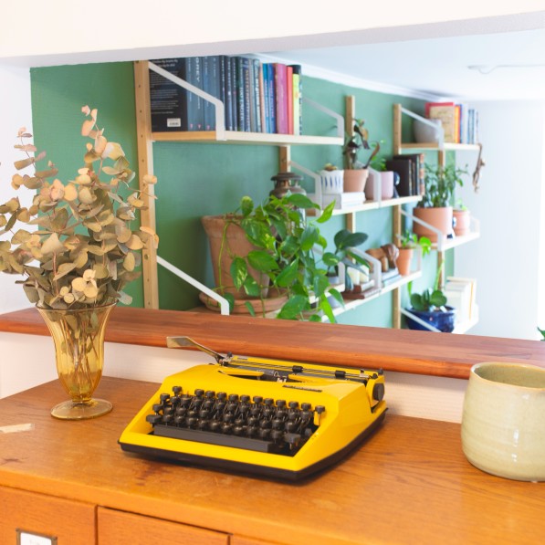 Gul skrivemaskine, blomster og spejl