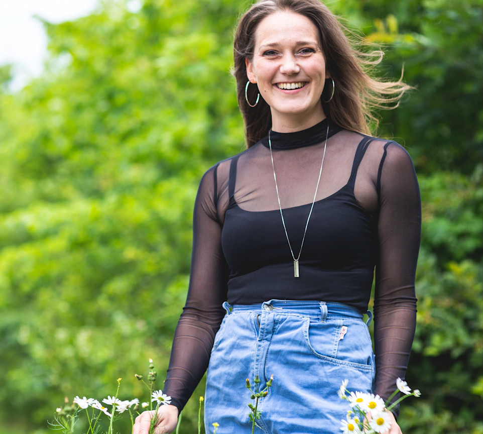 Iben Østergaard Fog smiler og holder nogle blomster i hænderne