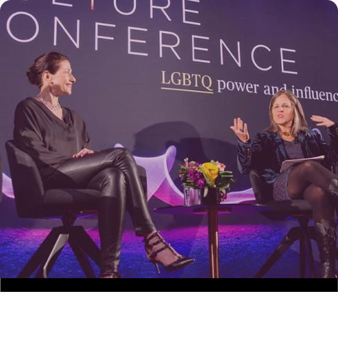 Three women sitting on stage and discussing