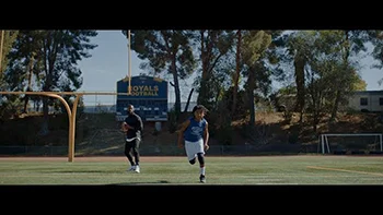 A father and son move across a football field.