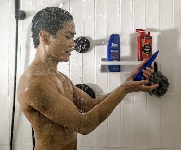 Man in shower squeezes Head & Shoulders shampoo into his hand.