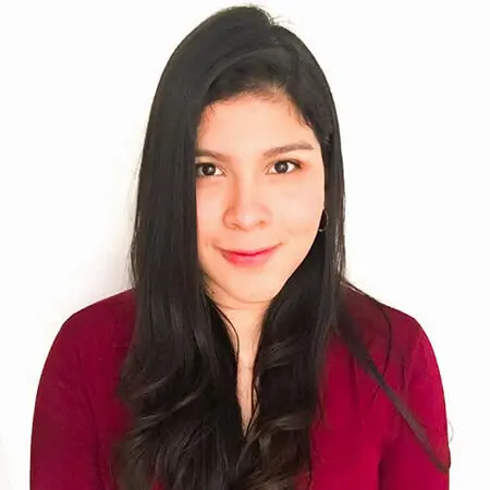 A young Hispanic woman with long dark hair and a red long-sleeved sweater smiles and poses for a headshot.