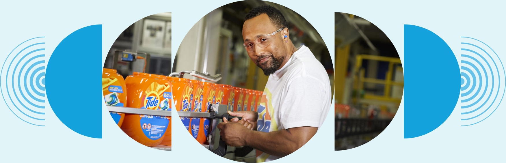 A man wearing safety glasses smiles as he monitors Tide Pods on a conveyor belt