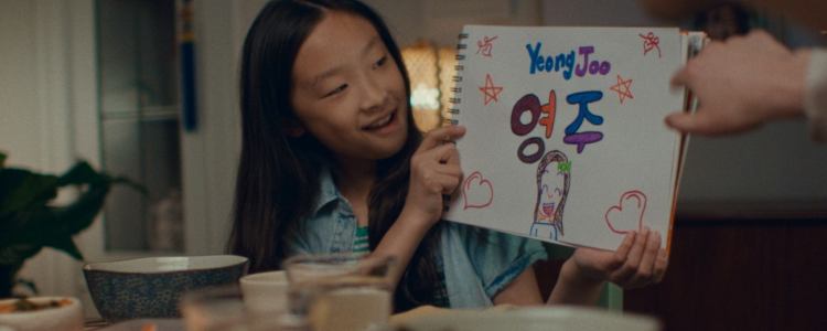 Asian american girl holding drawing of her name