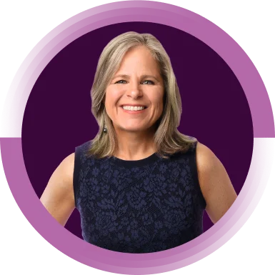 Shelly McNamara, Chief Equity and Inclusion Officer, is smiling directly towards the camera. She has short blonde hair and is wearing a black shirt.