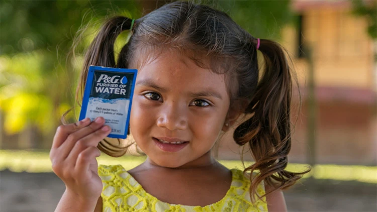 Child holding P&G Purifier of Water packet