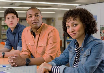 Three diverse people sitting and looking straight into the camera