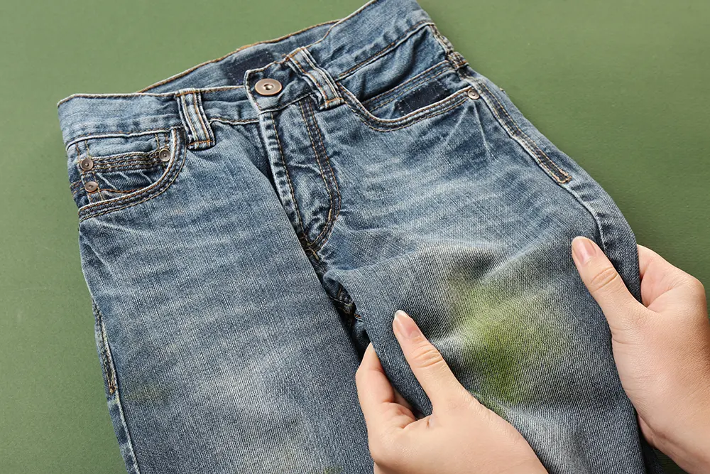 A pair of jeans with a grass stain