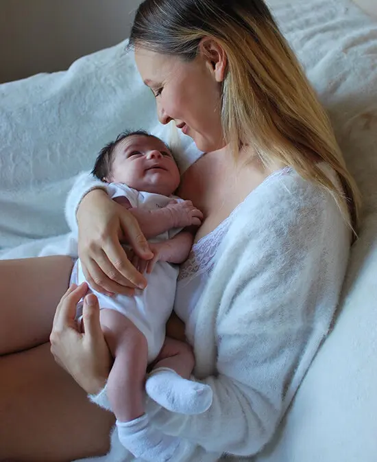 Olga Urbanovich, CEO of YogaMama, is pictured cradling her newborn child.