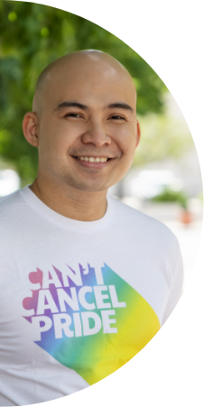 A man smiles while wearing a “Can’t Cancel Pride” t-shirt. 