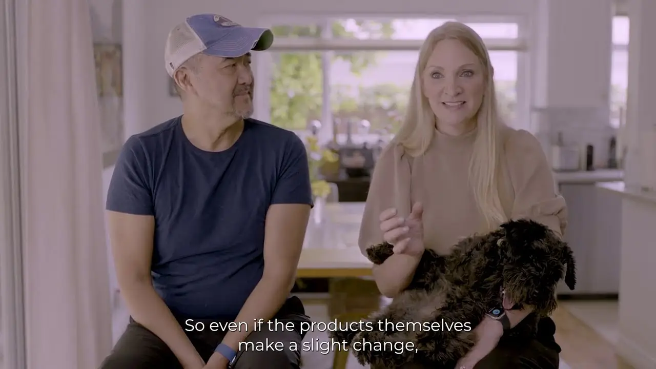 An Asian man and a white woman sit on stools in their home’s kitchen.