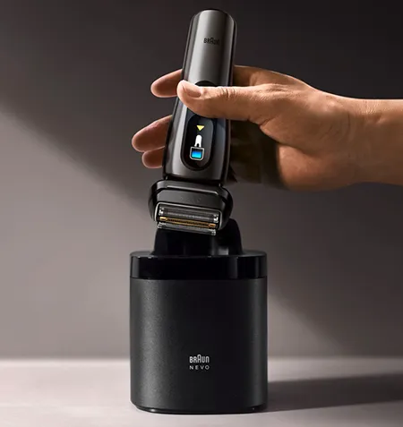 Braun NEVO shaver in the Care 7-in-1 cleaning base, showing the smart system that cleans, lubricates, dries and charges the device.