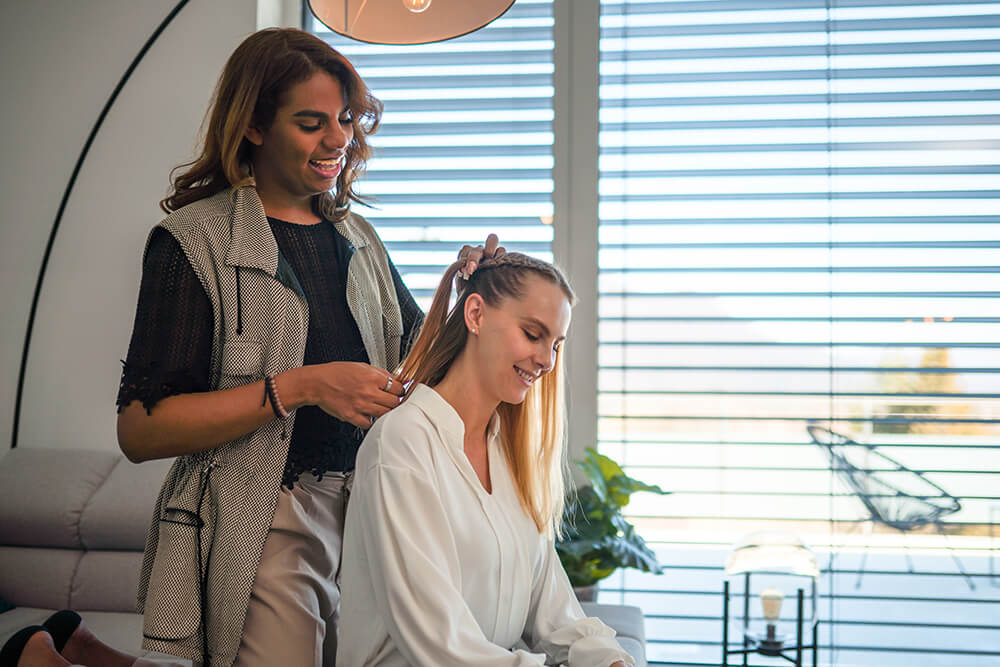 A girl making hair for another girl