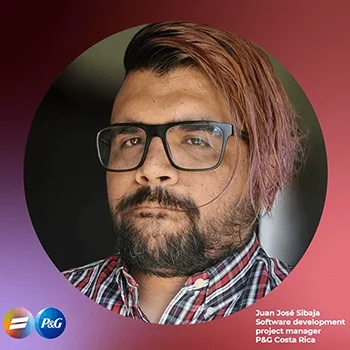 A headshot of a man with light brown skin, asymmetrical pink-orange hair, a dark beard and glasses. The photo is in a round frame with the name and title of the man, “Juan José Sibaja, Software development project manager P&G Costa Rica.”