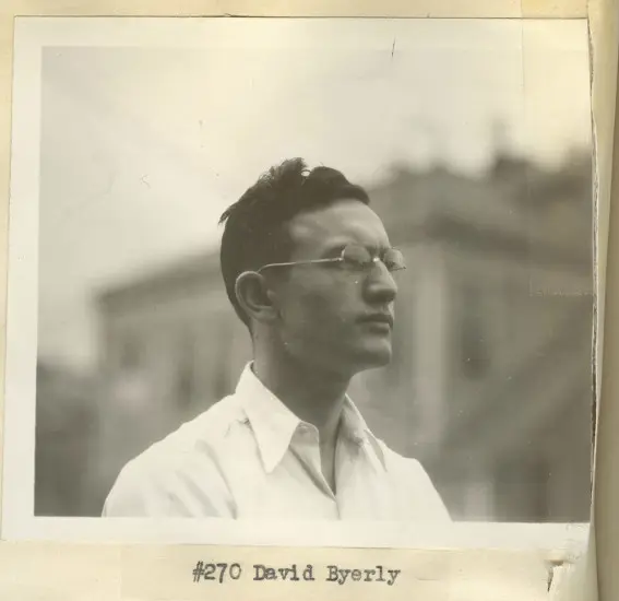 A black and white photo features a young man with dark hair and glasses. He wears a white buttoned shirt. Black text reads, "#270 David Byerly."