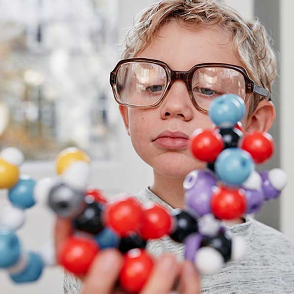 A child scientist looks at the molecular model