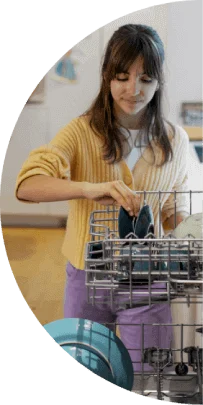 A teenage girl loads a dishwasher