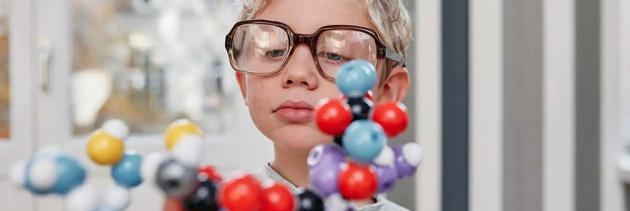A child scientist looks at the molecular model