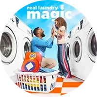 Adult and child placing laundry into a washing machine with a Tide detergent container in front