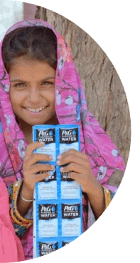 A young girl smiling and holding several P&G Purifier of Water packets.