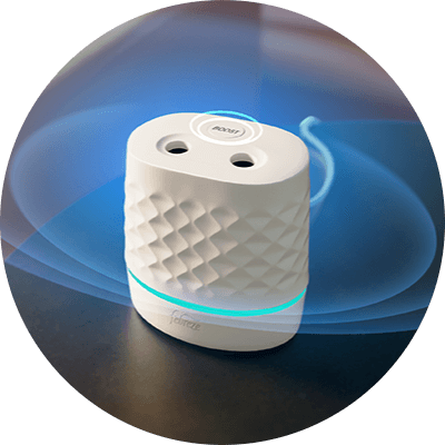 A white oval shaped device sits on a small end table. Two holes are at the top of the device, along with a button that says “boost.”