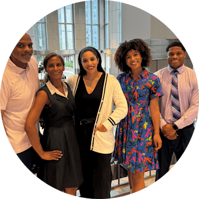 A family of five standing and smiling for a photo in the P&G lobby. 