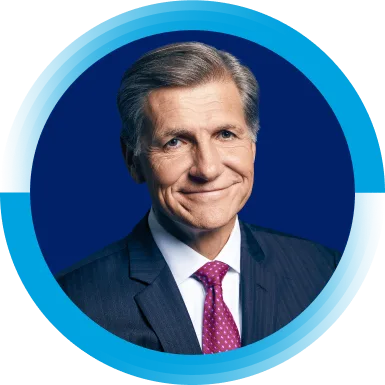 Marc Pritchard, Chief Brand Officer, is wearing a suit and purple tie. He is smiling at the camera.