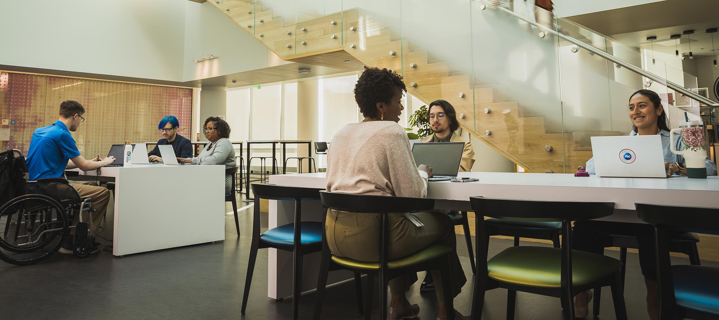 Several people sit together at various office work stations.