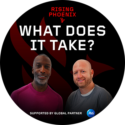 A black man in a red shirt and a white man in a grey shirt stand together and smile. A black background features red and white text at the top that says “Rising phoenix. What does it take?”