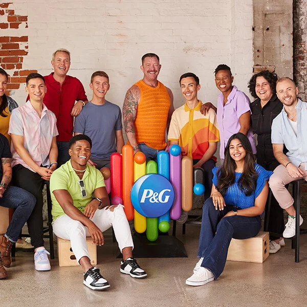 Employees standing around a rainbow heart with P&G logo