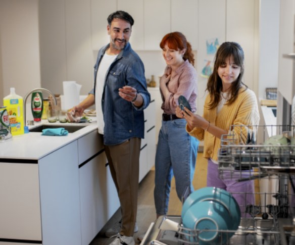 Man, woman and young girl are in kitchen washing and putting away dishes.