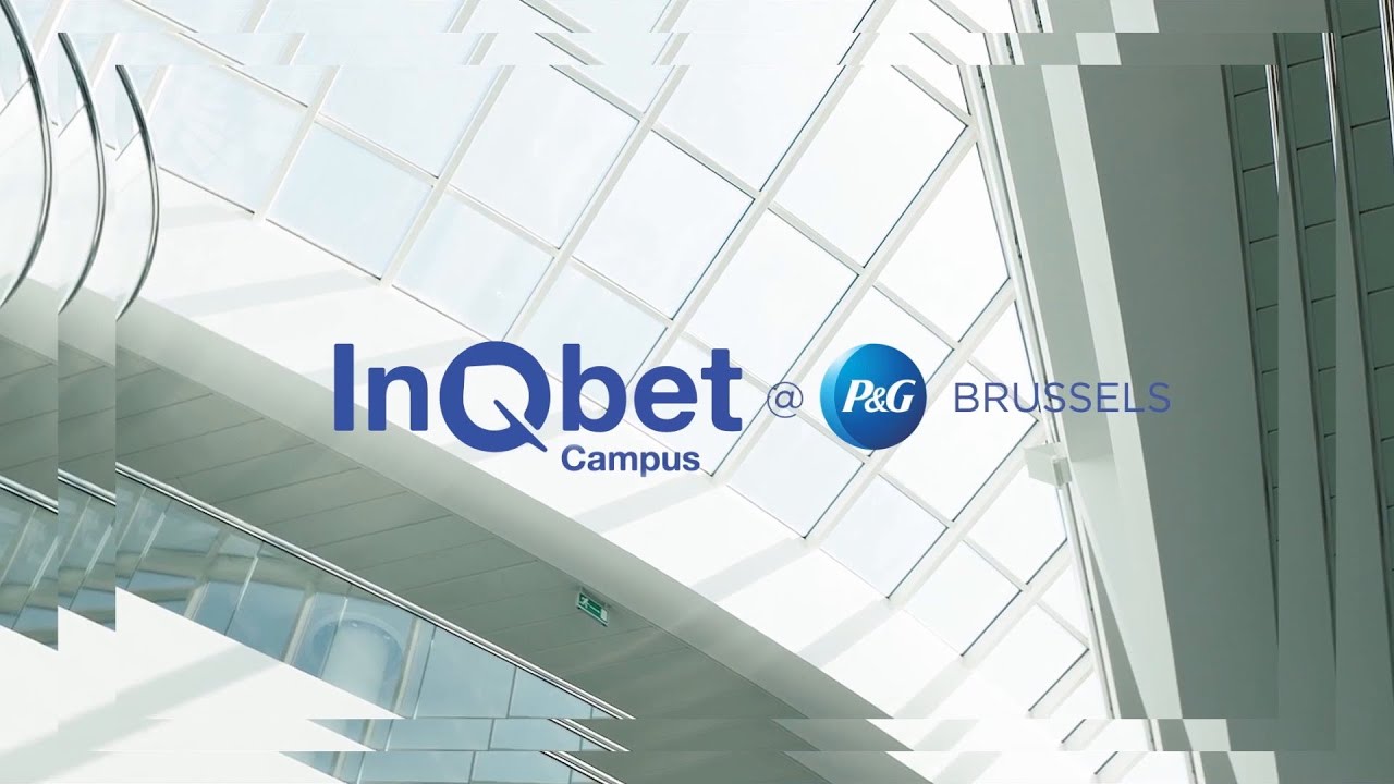 The interior of a building’s glass ceiling. Blue text says “InQbet campus at P&G Brussels.”